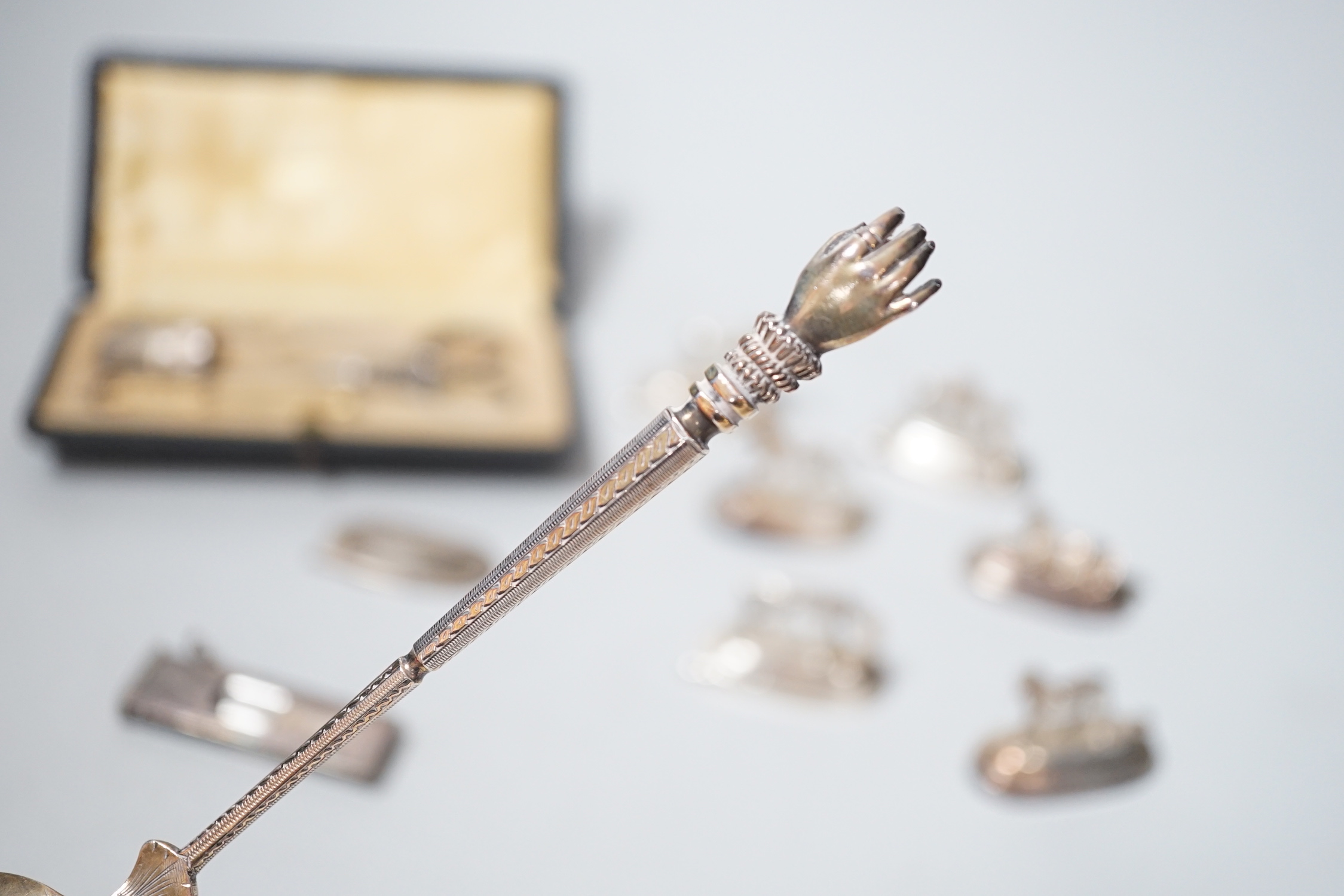 Six assorted Spanish white metal horse menu holders, 43mm, a cased necessaire set, a cigar cutter and a French white metal spoon with hand terminal.